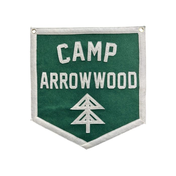 Green felt banner reading Camp Arrowwood with a cream pine tree