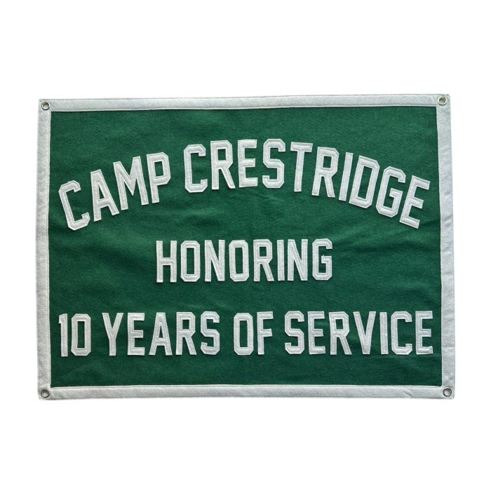 Green felt banner reading Camp Crestridge Honoring 10 Years of Service