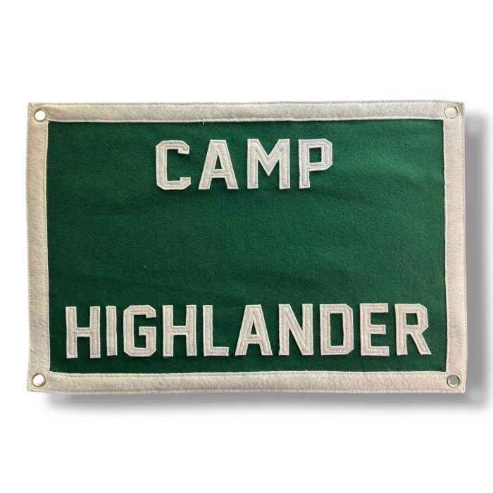 Green felt banner reading Camp Highlander with cream lettering and grommets