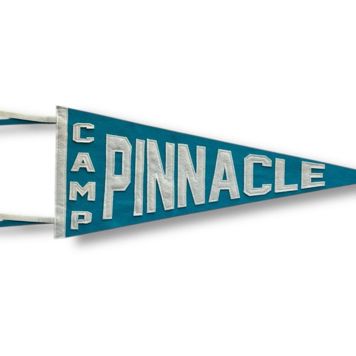 Teal felt Camp Pinnacle pennant with cream lettering and two ribbon tails