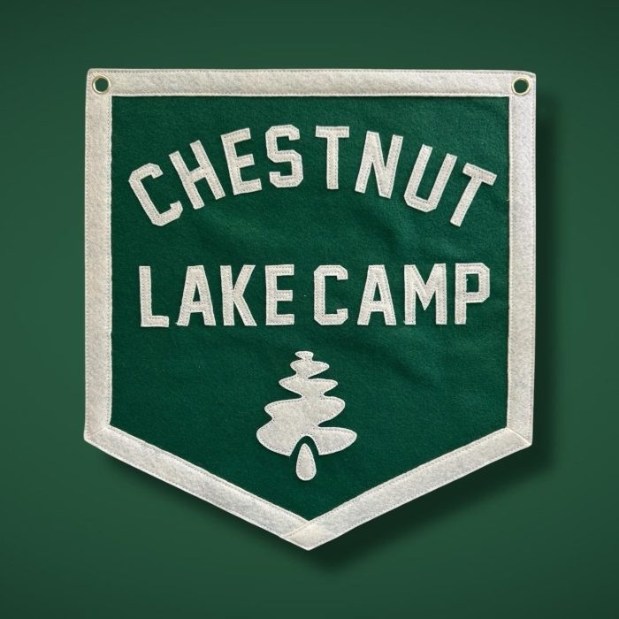 Green felt banner reading Chestnut Lake Camp with a cream pine tree