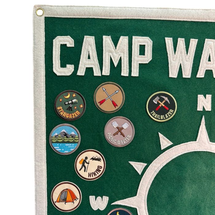 Close-up of Camp Wayfarer lettering and embroidered patches including stargazer, trailblazer and hiking