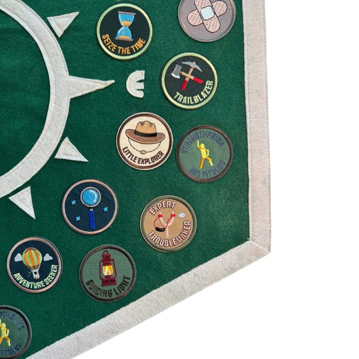 Close-up of round embroidered activity patches such as hiking, lantern and hot air balloon on a green pennant