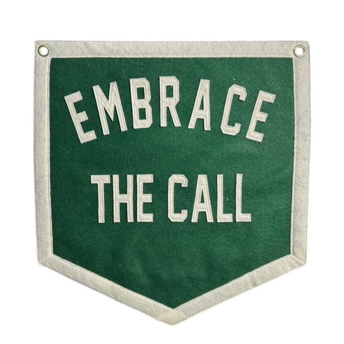 Green felt banner reading Embrace the Call in cream lettering