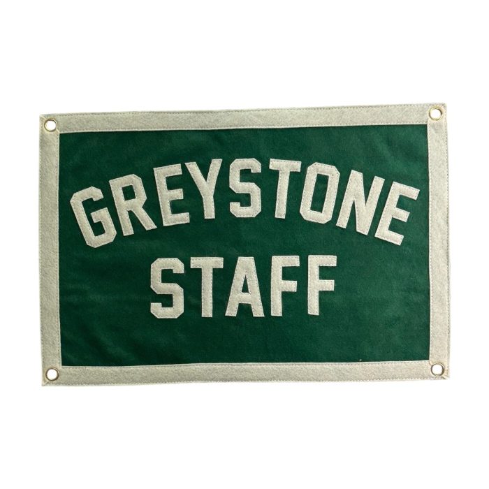 Green felt banner reading Greystone Staff in cream lettering